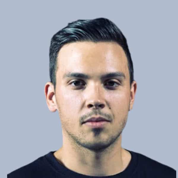 Homme professionnel regardant l'objectif, visage sérieux, fond gris clair.