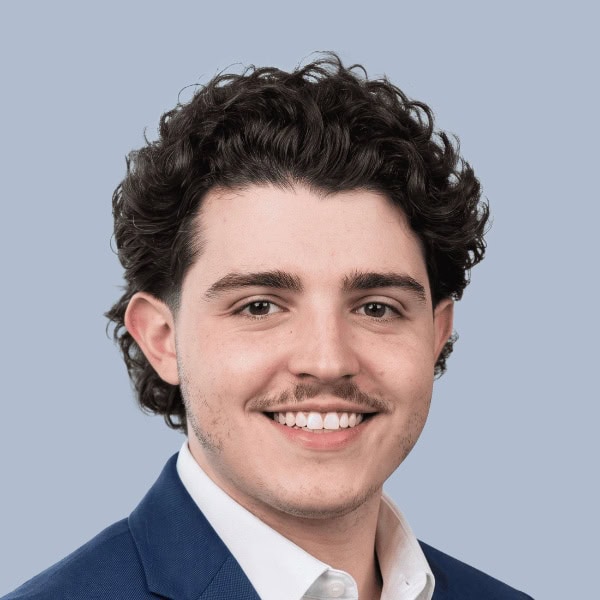Jeune homme souriant en costume pour OPTIMA.ai.